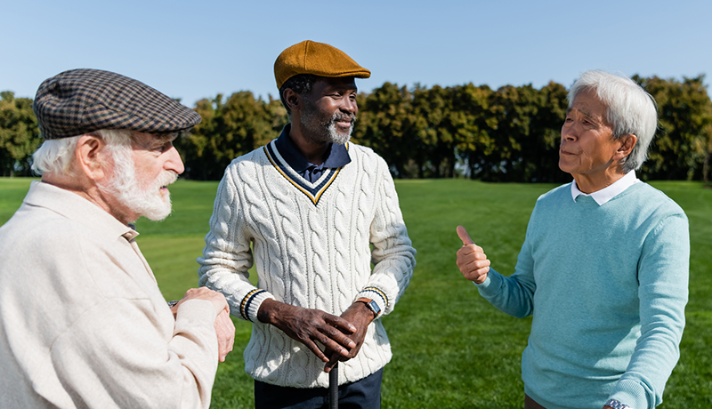 older male friends talking on golf course