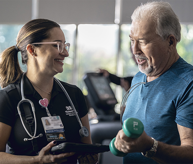 therapist with tablet monitoring patient using light weights