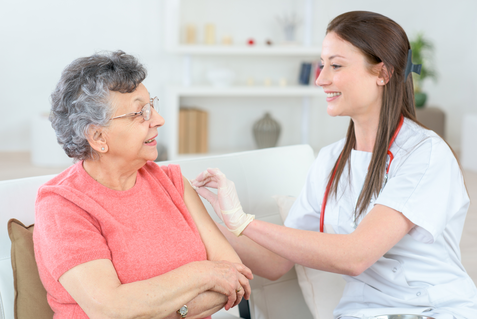 nurse injecting woman at home